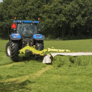 traktor z kosiarką koszący łąkę